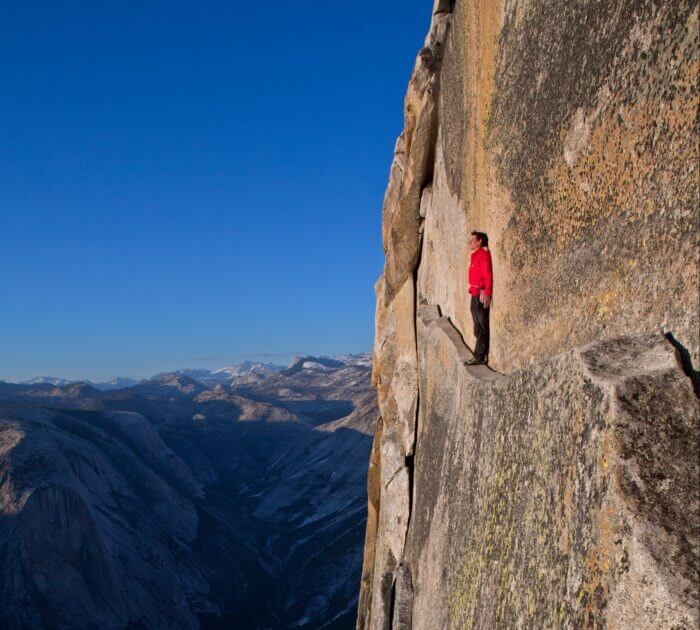 „To honnold“: Honnold balanciert auf dem Thank God Ledge in der Regular-Northwest-Route am Half Dome im Yosemite Valley – 600 Meter über dem Talboden. Später schrieb er: „Das Thank God Ledge mit dem Rücken zur Wand entlang zu spazieren